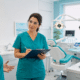 Coordinatrice di una clinica odontoiatrica ascolta una collega mentre vigila sulle procedure di sicurezza.